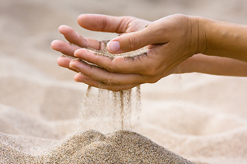 Image showing sand running through fingers of woman