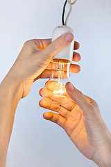 Image showing hands with incandescent light bulb