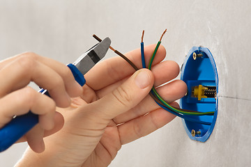 Image showing hand striping the insulation of wires