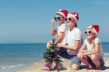 Image showing Three happy children  playing on the beach at the day time.