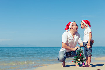 Image showing Father and son playing on the beach at the day time.