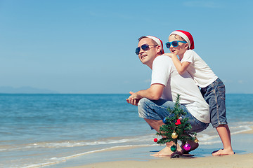 Image showing Father and son playing on the beach at the day time.