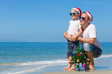 Image showing Father and son playing on the beach at the day time.