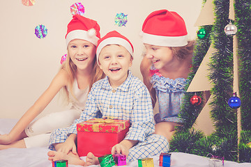 Image showing Happy little smiling boy and girls with christmas hat.