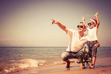 Image showing Father and son playing on the beach at the day time.