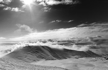 Image showing Black and white view on off-piste slope in clouds and sky with s