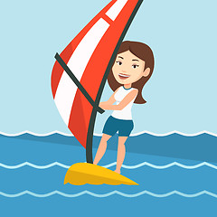 Image showing Young woman windsurfing in the sea.