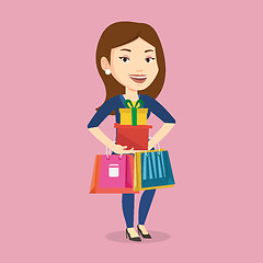 Image showing Happy woman holding shopping bags and gift boxes.