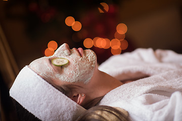 Image showing woman is getting facial clay mask at spa