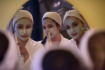 Image showing women putting face masks in the bathroom