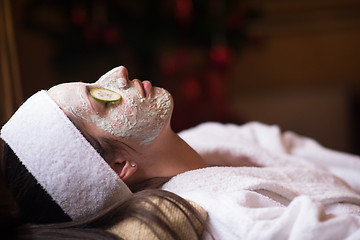 Image showing woman is getting facial clay mask at spa