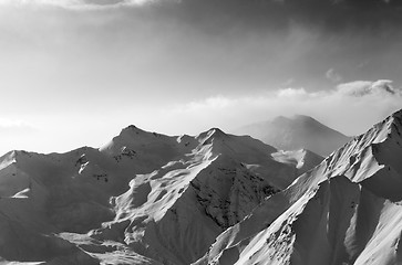 Image showing Black and white view on snowy sunlight mountains in early fog mo