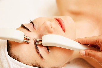 Image showing Cosmetology. Beautiful Woman At Spa Clinic Receiving Stimulating Electric Facial Treatment From Therapist. Closeup Of Young Female Face During Microcurrent Therapy. Beauty Treatment.