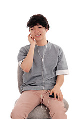 Image showing Asian teenager listening to music.