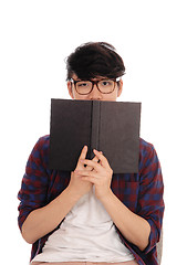 Image showing Asian man holding book for face.