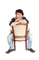 Image showing Asian man sitting backwards on chair.