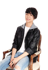 Image showing Asian teenager sitting in old armchair.
