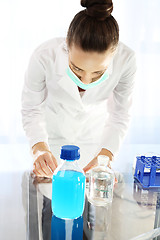 Image showing Chemist examine the sample under a microscope.