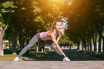 Image showing Fit fitness woman doing stretching exercises outdoors at park