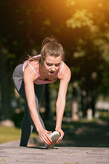 Image showing Fit fitness woman doing stretching exercises outdoors at park