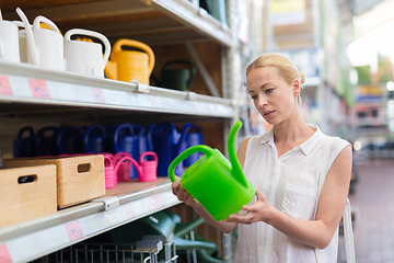 Image showing Woman choosing the right item for her apartment in a modern home furnishings store.