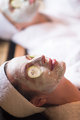 Image showing woman is getting facial clay mask at spa