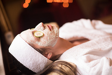 Image showing woman is getting facial clay mask at spa