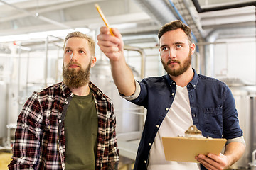 Image showing men with clipboard at craft brewery or beer plant