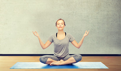 Image showing woman making yoga meditation in lotus pose on mat