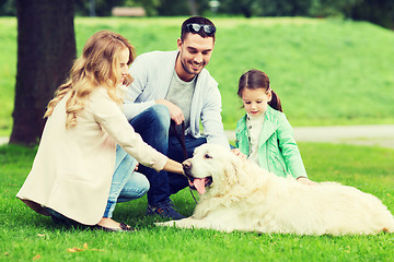 Image showing happy family with labrador retriever dog in park