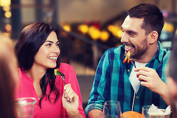 Image showing happy friends having dinner at restaurant