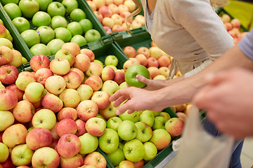 Image showing happy couple buying apples at grocery store