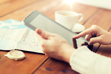 Image showing close up of traveler hands with tablet pc and map