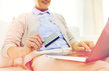 Image showing senior woman with laptop and credit card at home