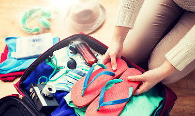 Image showing close up of woman packing travel bag for vacation