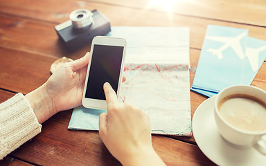 Image showing close up of traveler hands with smartphone and map