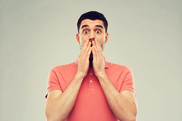 Image showing scared man in polo t-shirt over gray background