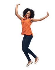 Image showing happy african american woman jumping over white