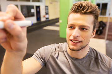 Image showing happy young man with marker writing in gym