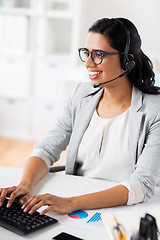 Image showing businesswoman with headset and keyboard at office