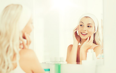 Image showing woman in hairband touching her face at bathroom