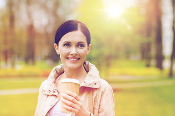 Image showing smiling woman drinking coffee in park