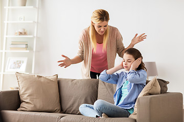 Image showing girl closing ears to not hear angry mother at home