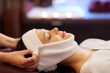 Image showing woman having face massage with towel at spa