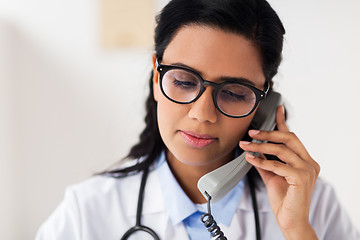 Image showing doctor in glasses calling on phone at hospital