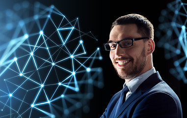 Image showing smiling businessman in glasses over black