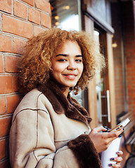 Image showing young pretty african american women drinking coffee outside in c