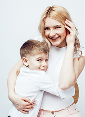 Image showing young modern blond curly mother with cute son together happy smiling family posing cheerful on white background, lifestyle people concept, sister and brother friends 