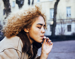 Image showing young pretty girl teenage outside smoking cigarette close up, lo