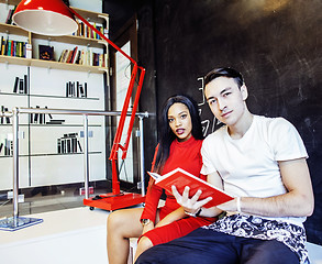Image showing couple students in univercity library, looking book, preparing t
